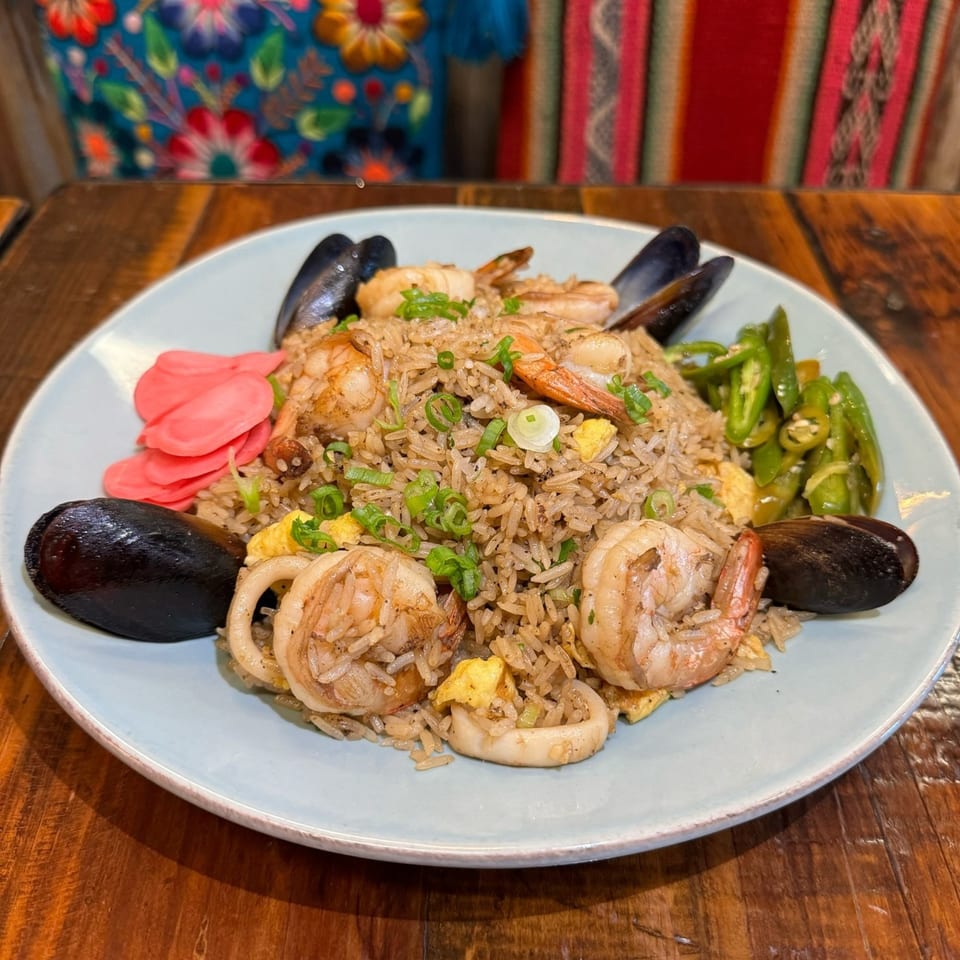 Peruvian arroz con mariscos with shrimp, mussels, calamari, pickled ginger, and green peppers.
